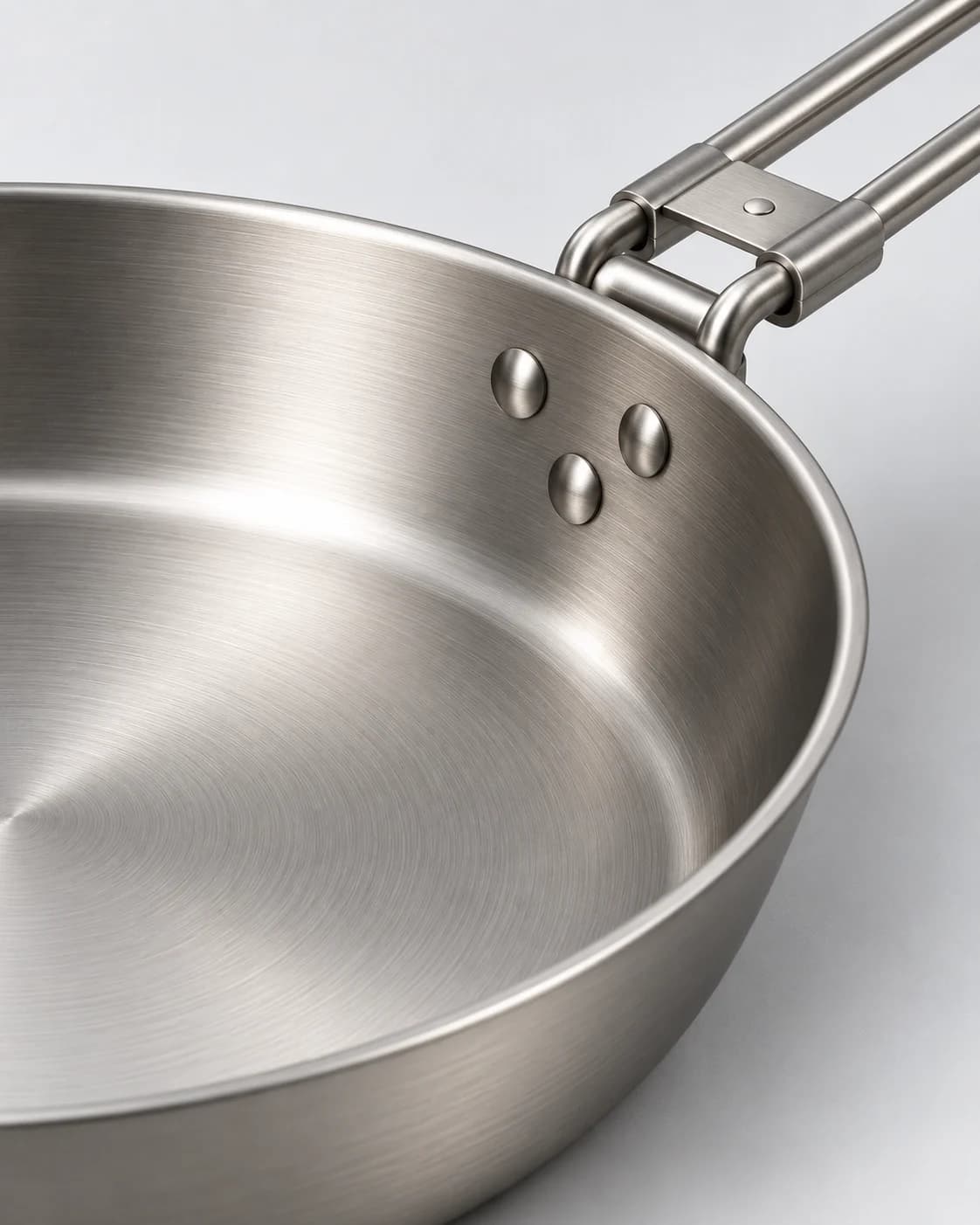 AI-generated illustrative close view of a frying pan rim and folding-handle connection