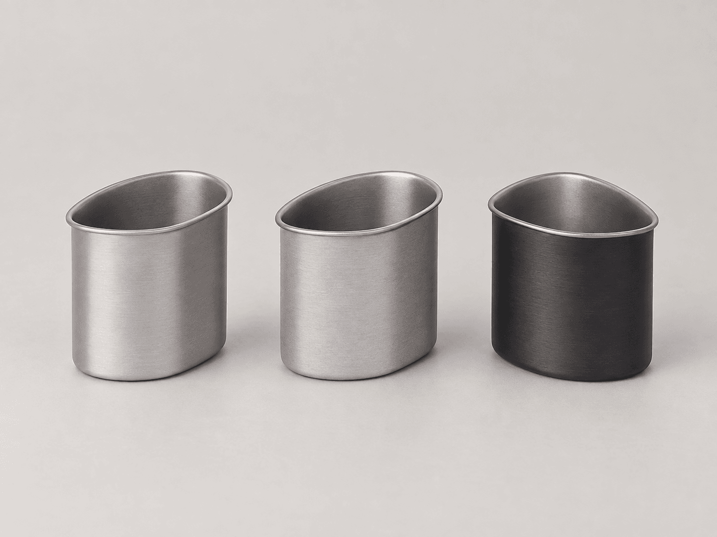 Titanium cups arranged on a light-grey studio background