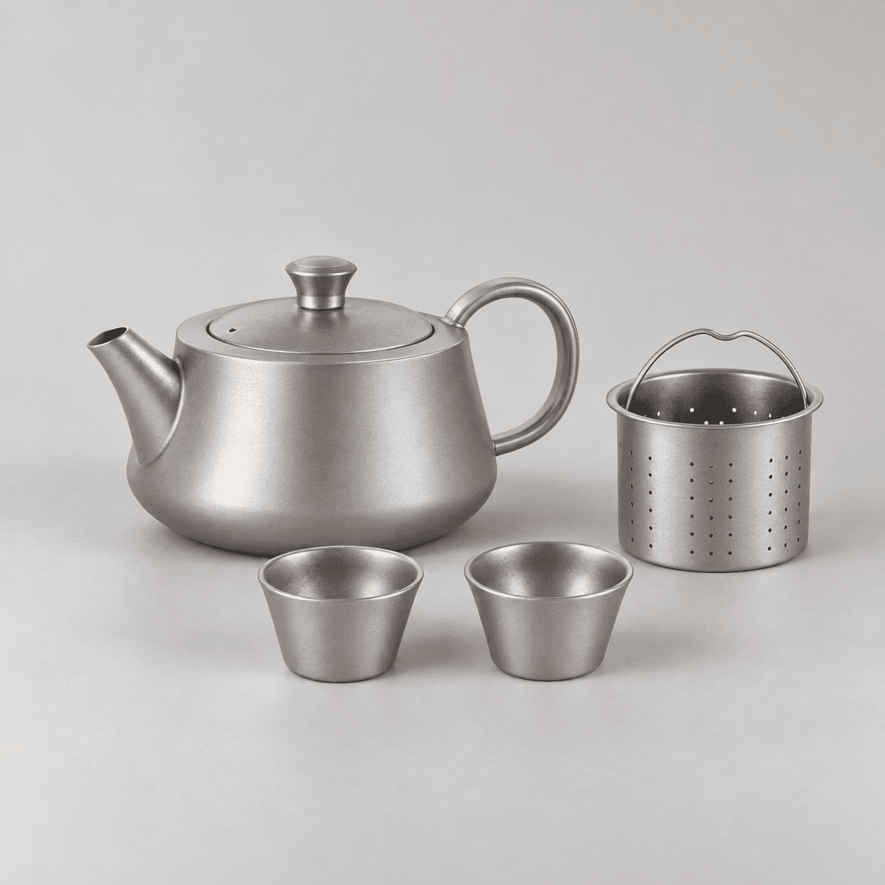 Catalog-referenced titanium tea ware with teapot, infuser, and cups